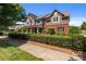 Charming two-story home featuring brick and stone accents, a covered porch, and mature landscaping at 126 Northbridge Dr, Mooresville, NC 28115