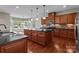Open kitchen with wood cabinets, granite countertops, island, and natural light from windows at 126 Northbridge Dr, Mooresville, NC 28115