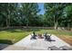 Backyard featuring a stone fire pit with chairs, complemented by mature trees and landscaping at 140 Robin Rd, Lincolnton, NC 28092