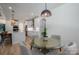Bright dining area with a round glass table, light wood floors and access to the modern white kitchen at 140 Robin Rd, Lincolnton, NC 28092