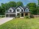 Charming two-story white home featuring black trim, front porch, and well-maintained landscaping at 140 Robin Rd, Lincolnton, NC 28092