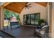 Covered patio with a swing, wicker furniture, and a view of the landscaped backyard and fire pit at 140 Robin Rd, Lincolnton, NC 28092