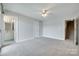 Spacious bedroom features neutral carpet, a ceiling fan, and an attached bathroom at 14053 Queens Harbor Rd, Charlotte, NC 28278