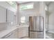 Bright kitchen featuring white cabinetry, stainless steel appliances and a window over the sink at 14053 Queens Harbor Rd, Charlotte, NC 28278