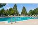 Community pool and lounge chairs surrounded by mature trees at 14053 Queens Harbor Rd, Charlotte, NC 28278