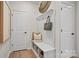 White mudroom bench with storage, hooks and adjacent doors at 15906 Parkside Crossing Dr # 317, Charlotte, NC 28273