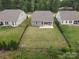 Aerial view of a fenced backyard with a covered porch and well-manicured lawn at 16112 Langston Dr, Charlotte, NC 28278