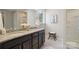 Bathroom with double vanity, granite top, framed mirror, and white framed window at 16112 Langston Dr, Charlotte, NC 28278