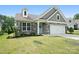 Inviting home with stone and gray siding, enhanced by lush landscaping and a green lawn at 16112 Langston Dr, Charlotte, NC 28278