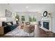 Inviting living room with a cozy fireplace, neutral decor, and large windows offering serene outdoor views at 16112 Langston Dr, Charlotte, NC 28278