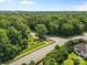 Aerial view of the community, showcasing lush trees and a road leading to a home with a serene setting at 1624 Moonstone Dr, Matthews, NC 28105