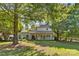 Grassy backyard surrounded by trees, featuring a deck and a porch, perfect for relaxation and outdoor gatherings at 1624 Moonstone Dr, Matthews, NC 28105