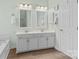 Bright bathroom featuring a double vanity, framed mirrors, and a bathtub at 1624 Moonstone Dr, Matthews, NC 28105