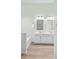 Bright bathroom with a double vanity, framed mirrors and wood look flooring at 1624 Moonstone Dr, Matthews, NC 28105