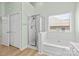 Bright bathroom with a glass shower, soaking tub, and double door closet at 1624 Moonstone Dr, Matthews, NC 28105