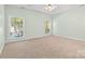 Neutral bedroom featuring two windows, a ceiling fan, and soft carpet flooring at 1624 Moonstone Dr, Matthews, NC 28105