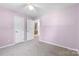 Bedroom featuring a light purple wall, neutral carpet and double doors at 1624 Moonstone Dr, Matthews, NC 28105