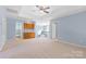 Spacious bonus room featuring a wet bar, neutral carpet, and blue walls at 1624 Moonstone Dr, Matthews, NC 28105