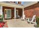 Inviting front porch features a cozy bench, white Adirondack chairs, and a brick exterior at 1624 Moonstone Dr, Matthews, NC 28105