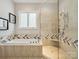 Luxurious bathroom showcasing a soaking tub, a walk-in shower with a bench, and elegant tile work at 172 Barber Loop, Mooresville, NC 28117