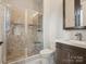 Bathroom featuring a glass-enclosed shower with tiled walls and floors, plus a modern vanity with chrome fixtures at 172 Barber Loop, Mooresville, NC 28117