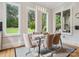 Bright dining room with a glass table, modern chrome chairs, and large windows offering scenic backyard views at 172 Barber Loop, Mooresville, NC 28117