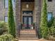 Inviting entryway featuring a brick facade, black double doors, and manicured greenery on either side of the steps at 172 Barber Loop, Mooresville, NC 28117