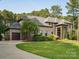 Stately brick home with a well-manicured lawn, mature trees, and a curved driveway leading to a two-car garage at 172 Barber Loop, Mooresville, NC 28117