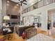 Bright, open living room with a stone fireplace, hardwood floors, and an elegant wrought iron balcony at 172 Barber Loop, Mooresville, NC 28117