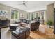 Spacious living room with hardwood floors, a large leather sectional, and multiple windows providing abundant natural light at 172 Barber Loop, Mooresville, NC 28117