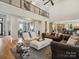 Open-concept living area with hardwood floors, a stylish seating arrangement, and connected kitchen and dining spaces at 172 Barber Loop, Mooresville, NC 28117