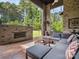 Outdoor patio featuring a brick fireplace, comfortable lounge seating, and views of the lush green backyard at 172 Barber Loop, Mooresville, NC 28117