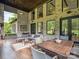 Covered patio with ample seating, a dining table, and large windows offering views of the surrounding greenery at 172 Barber Loop, Mooresville, NC 28117