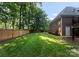 Lush backyard with a well-maintained lawn, privacy fence, and mature trees at 2100 Chesterfield Ave, Charlotte, NC 28205
