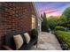 Inviting front exterior featuring a stone pathway, bench with pillows, and lush landscaping at 2100 Chesterfield Ave, Charlotte, NC 28205