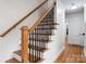 A staircase with hardwood steps and decorative black iron railing at 2100 Chesterfield Ave, Charlotte, NC 28205