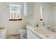 A bright bathroom features a single sink vanity with storage, a toilet, and shower/tub with coordinated decor at 2105 Florida Ave, Kannapolis, NC 28083