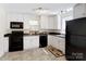 Bright kitchen with white cabinets, black appliances, and eat-in area with natural light at 2105 Florida Ave, Kannapolis, NC 28083