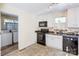 Bright kitchen with white cabinets, black appliances, and entrance to laundry room at 2105 Florida Ave, Kannapolis, NC 28083