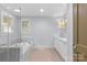 Bright bathroom with a bathtub and shower with tiled walls and flooring, a window, and white vanity at 2112 Shenandoah Ave, Charlotte, NC 28205