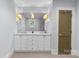 Updated bathroom with large mirror above the sink, marble countertop, white vanity, and silver accents at 2112 Shenandoah Ave, Charlotte, NC 28205
