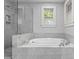 Contemporary bathroom boasts a glass-enclosed shower and tub, with marble tile, and a window for natural lighting at 2112 Shenandoah Ave, Charlotte, NC 28205