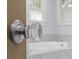 Close-up of a clear door knob with silver hardware, and an out-of-focus white bathtub is visible in the background at 2112 Shenandoah Ave, Charlotte, NC 28205