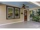 Inviting front porch showcasing a ceiling fan and a classic wooden front door with a glass insert at 2112 Shenandoah Ave, Charlotte, NC 28205