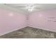 Bright pink bedroom offers neutral carpeting and a ceiling fan at 2229 Old Wilkesboro Rd, Statesville, NC 28625