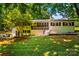 Charming painted brick home with a cozy porch and mature trees surrounding the property at 2229 Old Wilkesboro Rd, Statesville, NC 28625