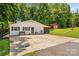 Exterior view with white brick, shutters, a small bench, and lush green trees offering curb appeal at 2229 Old Wilkesboro Rd, Statesville, NC 28625