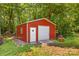 Backyard shot of the outbuilding featuring a roll-up door, offering ample storage or workshop space and blending into the landscape at 2229 Old Wilkesboro Rd, Statesville, NC 28625