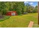 Exterior view of the storage shed nestled in the backyard, providing practical storage solutions and blending with the landscape at 2229 Old Wilkesboro Rd, Statesville, NC 28625