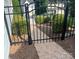 Wrought iron gate leading to a charming backyard oasis with brick pathway, mature bushes, and scenic views at 2300 Wednesbury Ct, Kannapolis, NC 28083